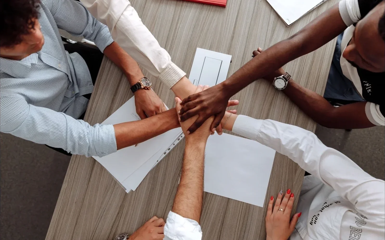 Students clasping hands in a circle, viewed from above